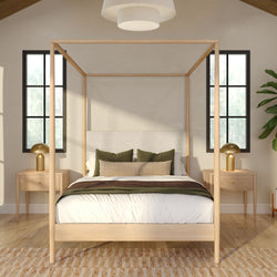 Modern minimalist bedroom with light wood four-poster bed, neutral bedding, green accent pillows, matching nightstands and gold lamps by tall windows