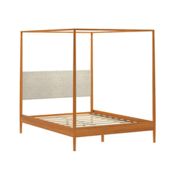 Mid-century modern wooden canopy bed frame with four posts, slatted platform base and beige upholstered headboard in warm oak finish