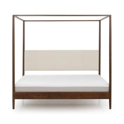 Modern walnut four-poster canopy bed with beige upholstered headboard and white mattress, minimalist bedroom furniture