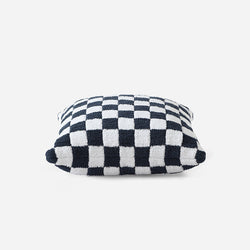 Checkered pattern decorative throw pillow with black and white squares on a white background.