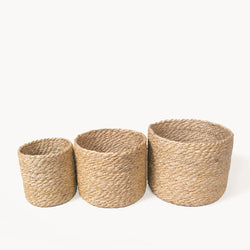 Set of three natural woven jute storage baskets in varying sizes.