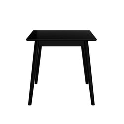 Black modern dining table with sleek wooden legs on a white background.