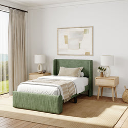Modern bedroom with green upholstered bed, beige bedding, abstract wall art, and wooden nightstands, featuring natural light and cozy decor.