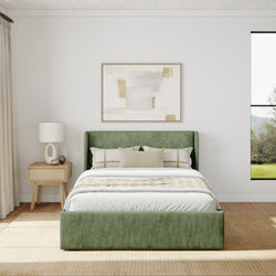Modern bedroom interior with green upholstered bed, abstract wall art, and natural light.