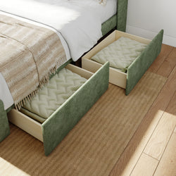 Underbed storage drawers with green fabric covering and warm blankets inside on wooden flooring.