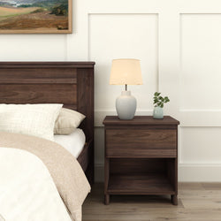 Elegant bedroom scene with a wooden nightstand, ceramic lamp, and minimalist bedding.