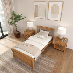 Cozy modern Scandinavian single bedroom interior with oak wooden bed and matching nightstands, neutral linen bedding, table lamps, potted indoor plant, abstract wall art, hardwood floors and large window natural light