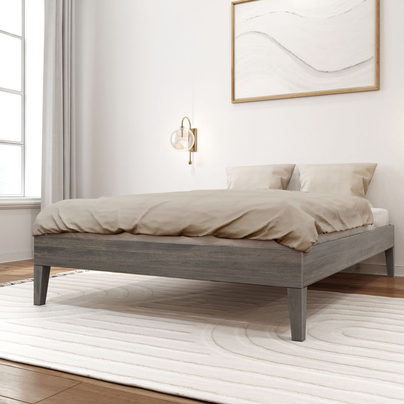Minimalist neutral bedroom with modern gray wood bed frame, beige linen bedding, round brass wall sconce, abstract framed art and soft natural window light