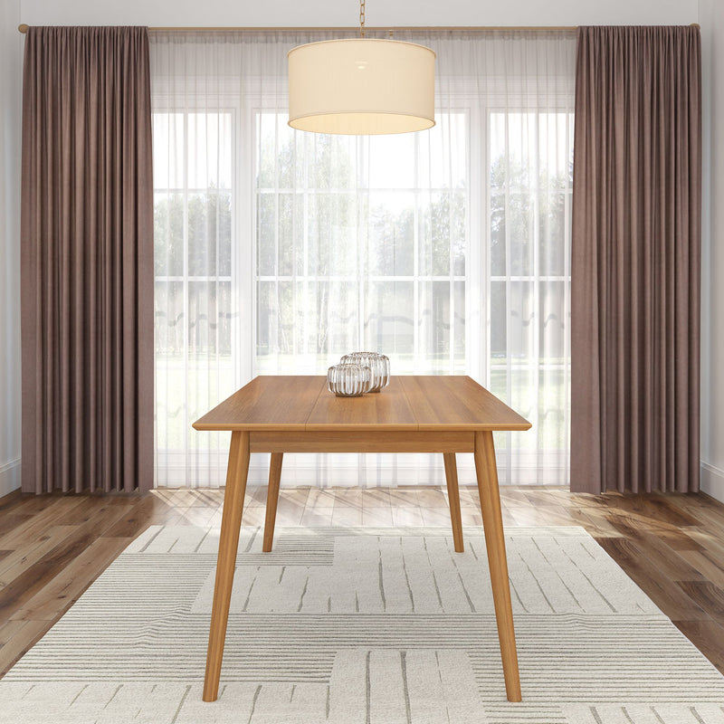 Modern wooden dining table in a bright room with elegant curtains and large windows.