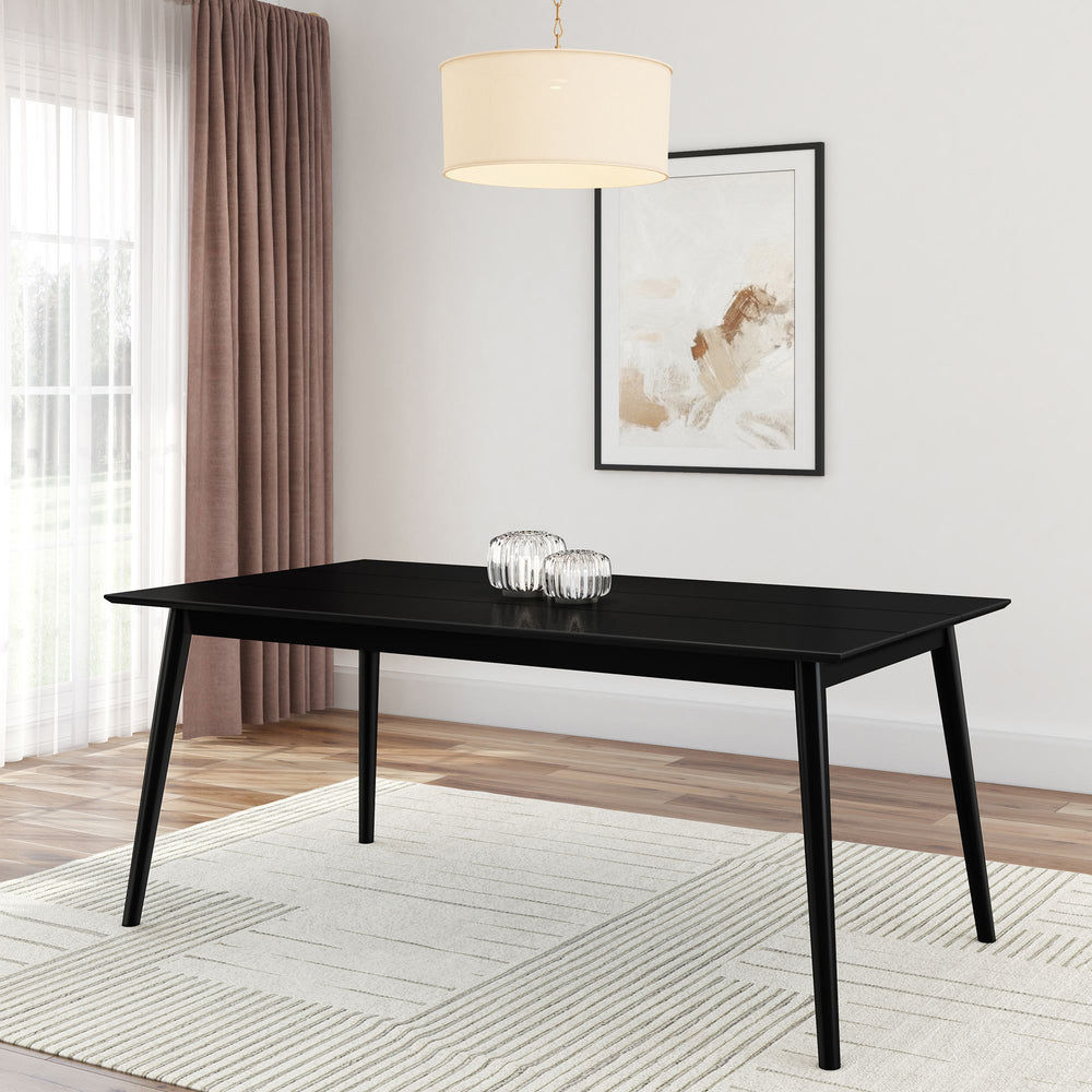 Modern black dining table with decorative glass ornaments in a stylish dining room setting.