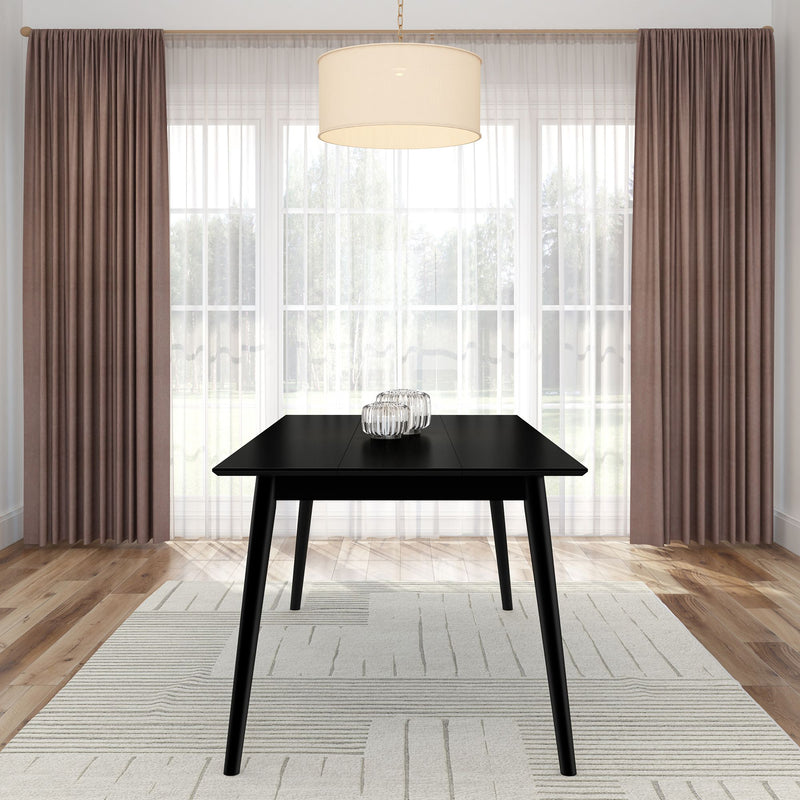 Modern black dining table in a bright room with elegant curtains and a pendant light.