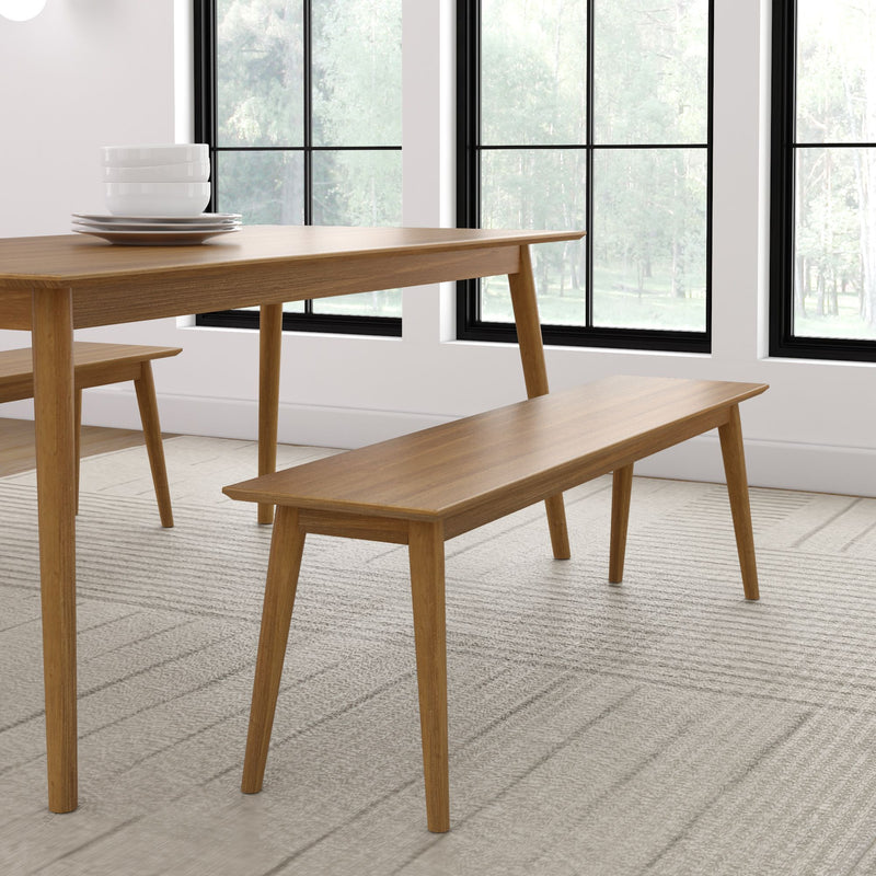 Modern wooden dining table and bench set in minimalist room with large windows.