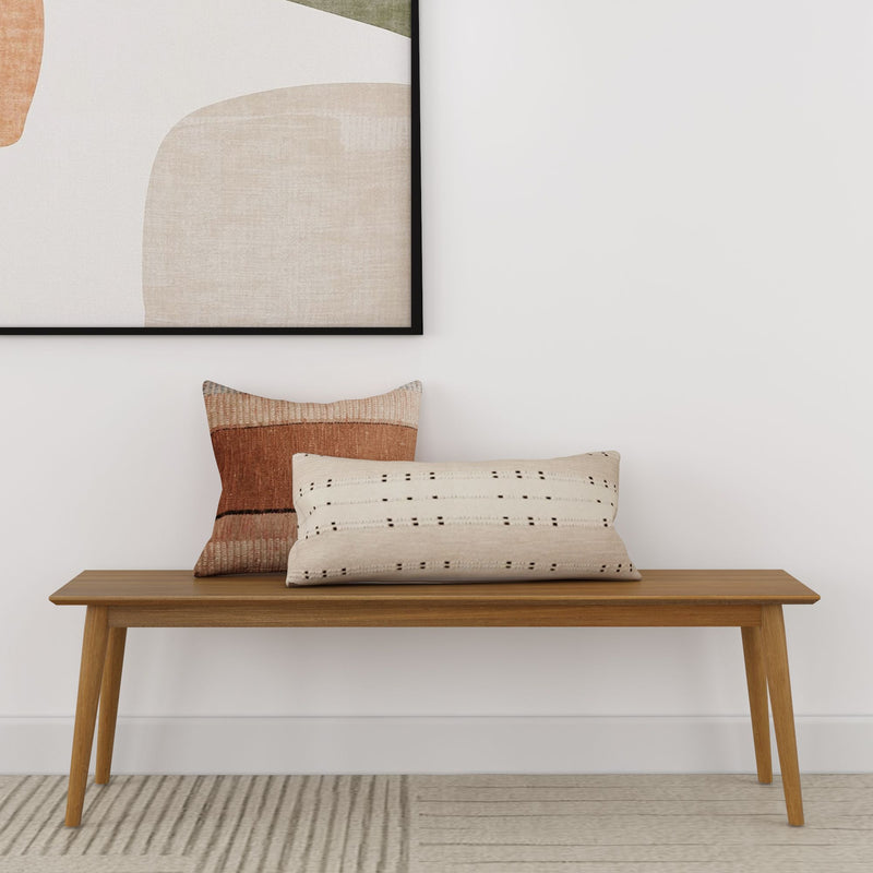 Mid-century modern wooden bench with decorative pillows in minimalist living room.