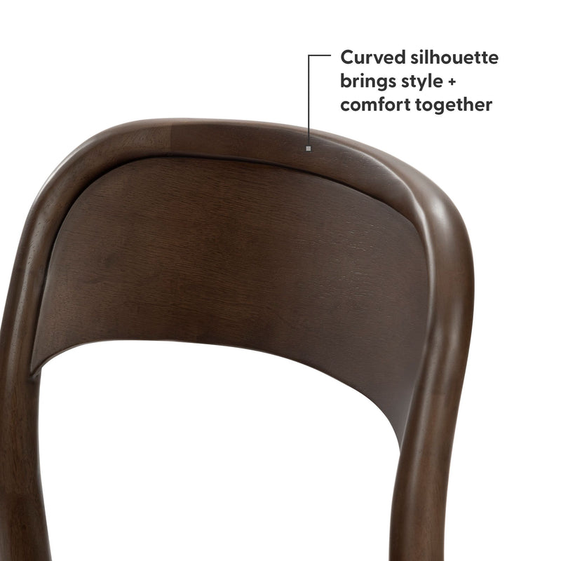 Close-up of curved wooden dining chair back in dark walnut finish, mid-century modern ergonomic silhouette with smooth wood grain