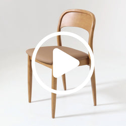 Elegant wooden dining chair with curved backrest and cushioned seat in a modern minimalist style.