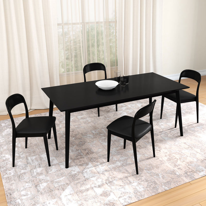 Modern black dining table set with four black chairs on a neutral patterned area rug in a bright dining room, rectangular minimalist table with white bowl and glasses centerpiece, sheer window curtains and light wood flooring