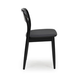 Side view of a black modern dining chair with curved backrest, padded seat and tapered legs, minimalist Scandinavian design