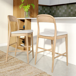 Modern wooden bar stools with white cushions in a stylish kitchen setting.