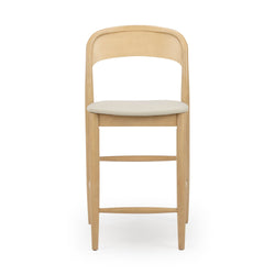 Mid-century modern light wood bar stool with beige padded seat, curved backrest and footrest on white background
