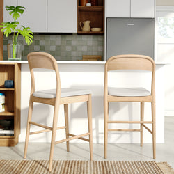 Light wood counter-height bar stools at a white kitchen island in a modern Scandinavian kitchen with green tile backsplash, gray refrigerator and potted plant