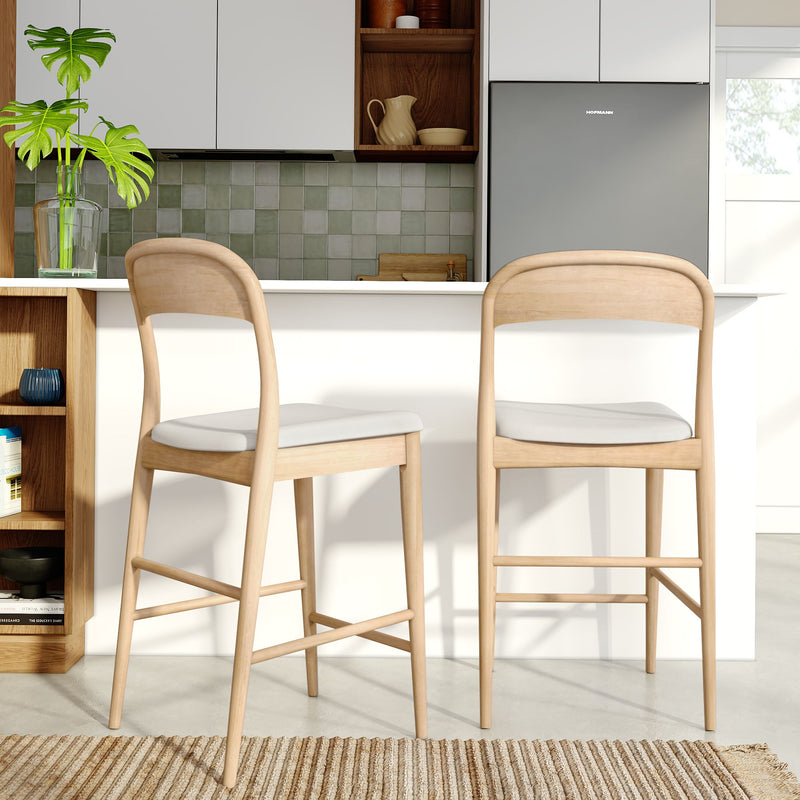 Light wood counter-height bar stools at a white kitchen island in a modern Scandinavian kitchen with green tile backsplash, gray refrigerator and potted plant