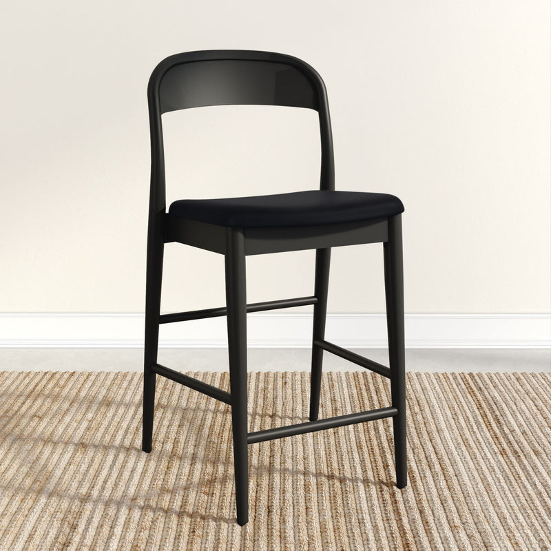 Modern black barstool with sleek design on a textured beige rug in a minimalist room setting.