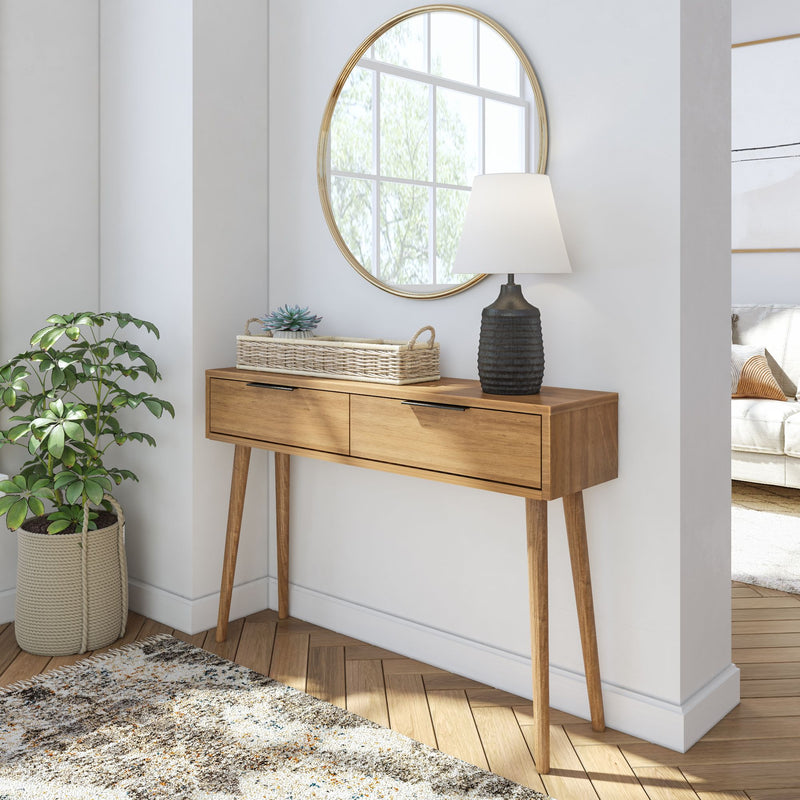 Stylish mid-century modern wooden console table with drawers, topped with a chic lamp and wicker basket, set against a round mirror and a leafy green plant beside a cozy living room.