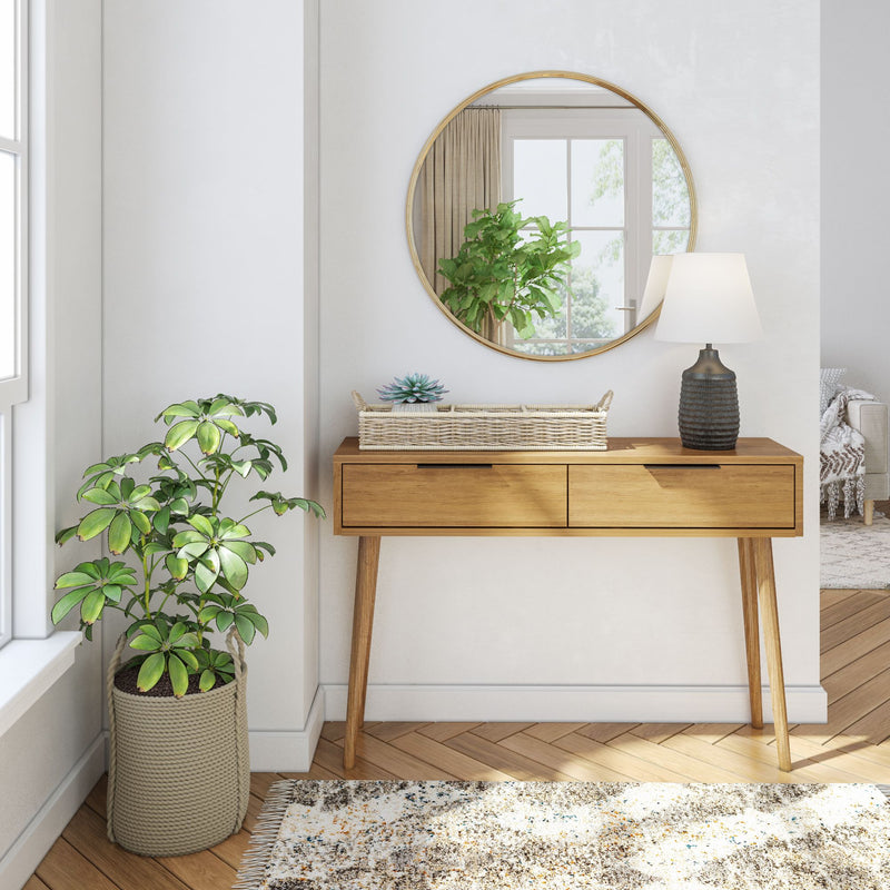 Elegant modern entryway with wooden console table, round mirror, and indoor plant decor.