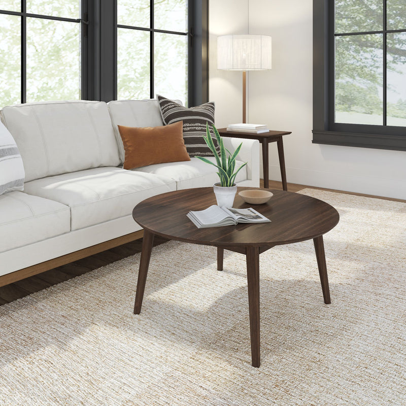 Modern living room with white sofa, dark wood coffee table, and decorative pillows.
