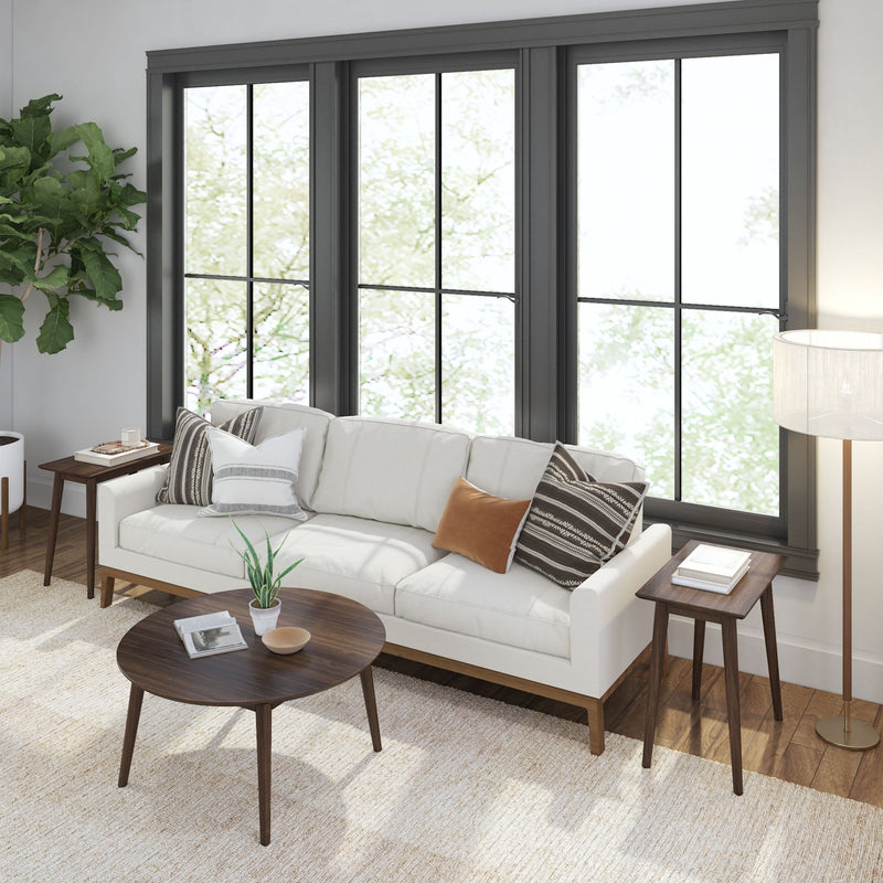 Cozy modern living room with white sofa, wooden coffee table, large window, and stylish decor.