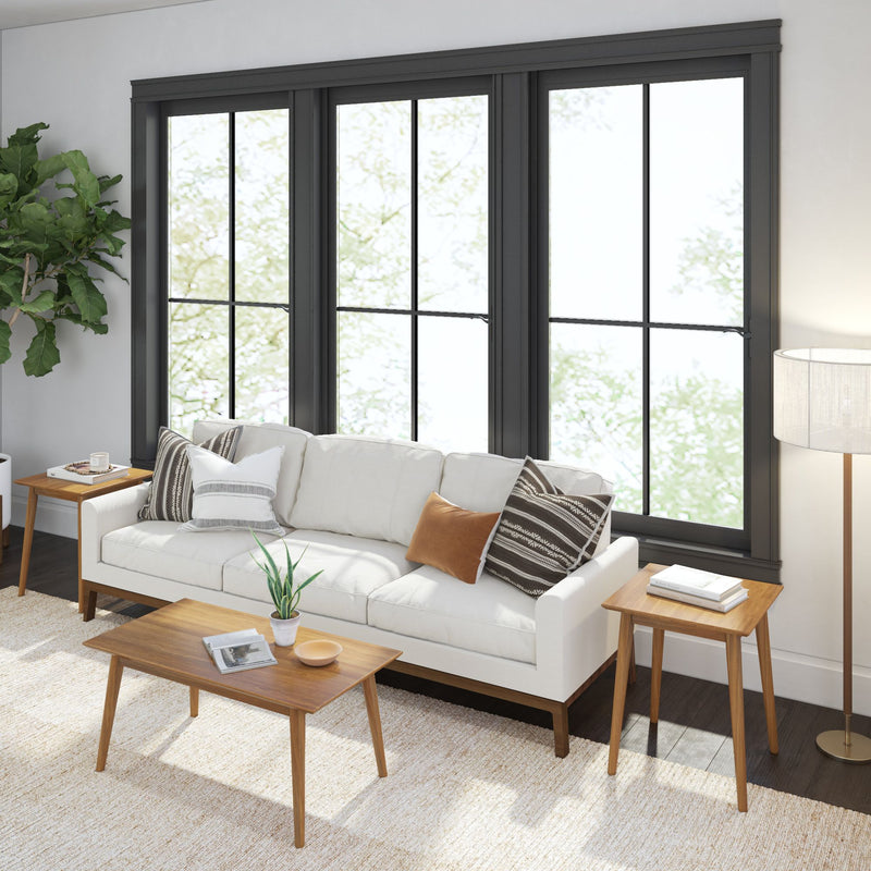 Modern living room with white sofa, wooden coffee table, and large windows.