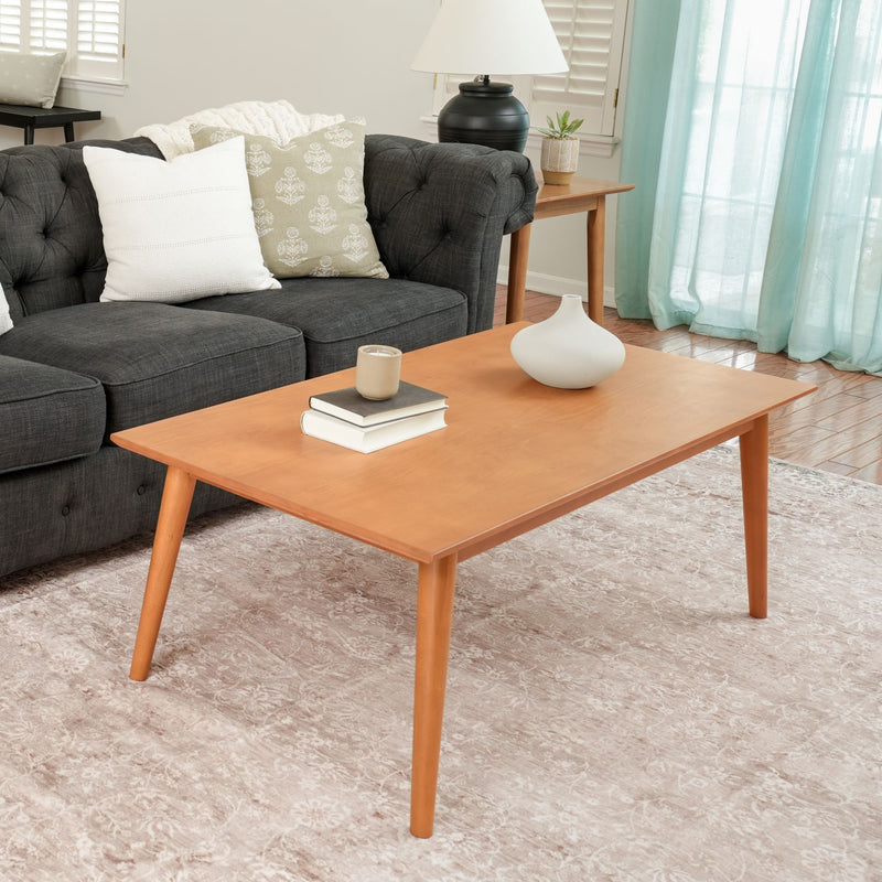 Mid-century modern living room with a wooden coffee table, gray tufted sofa, and decorative pillows.