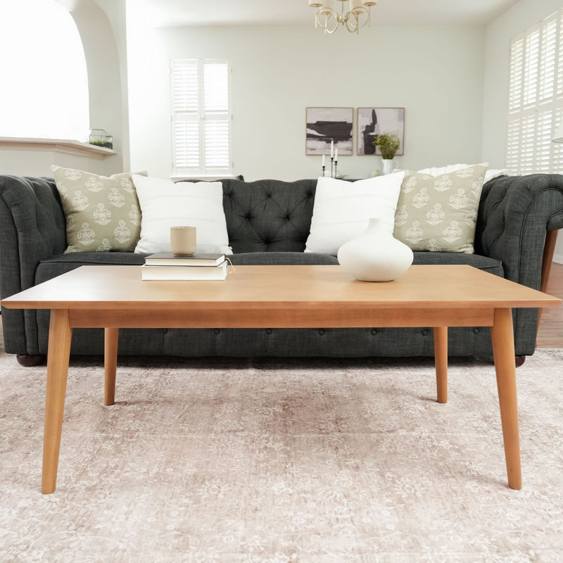 Mid-century modern living room with stylish green sofa, wooden coffee table, and decorative pillows for contemporary home decor.