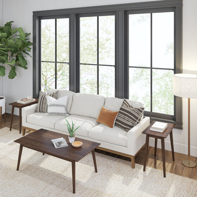 Modern living room interior with a white sofa, decorative pillows, wooden coffee table, and floor lamp near large windows, optimized for stylish home decor inspiration.