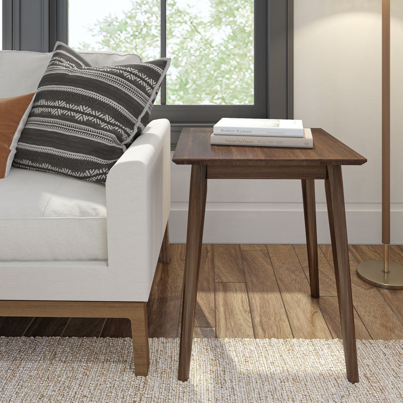 Mid-century modern wooden side table next to white sofa in living room.