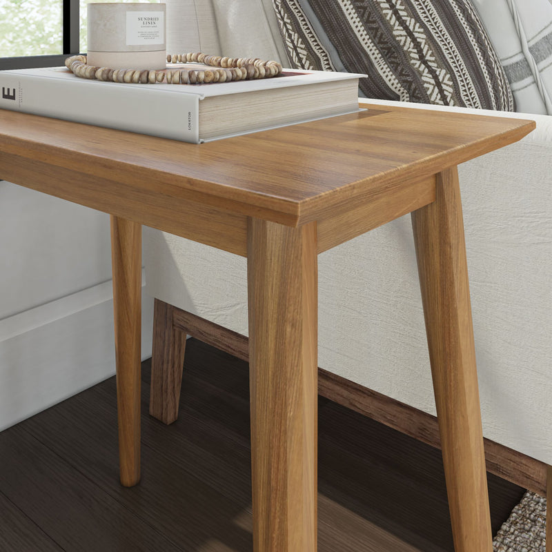 Wooden side table with books and candle for cozy home decor.