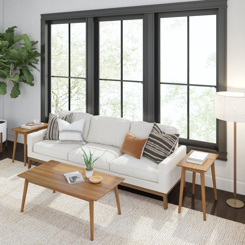 Modern living room with a white sofa, wooden coffee table, and large windows featuring black frames.