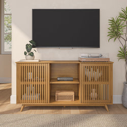 Modern living room setup with a wooden TV stand, flat-screen TV, and decorative plants.