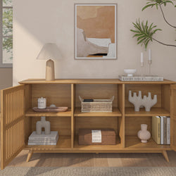 Modern wooden sideboard with decorative items and minimalist art in a cozy living room setting.