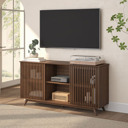 Mid-century modern walnut media console with slatted doors holding turntable, AV components and books under wall-mounted flat-screen TV in bright living room