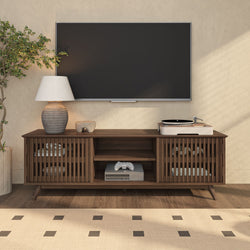 Modern living room entertainment center with wall-mounted flat-screen TV, mid-century wooden media console, turntable, table lamp, game controller, and indoor plant.