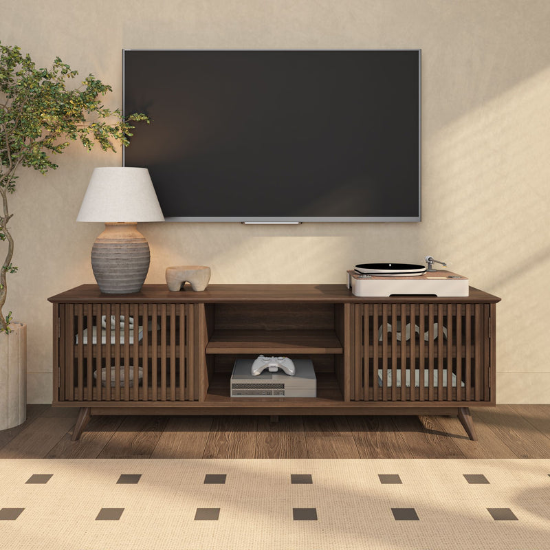 Modern living room entertainment center with wall-mounted flat-screen TV, mid-century wooden media console, turntable, table lamp, game controller, and indoor plant.