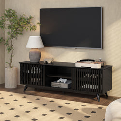 Modern living room with sleek black media console, flat-screen TV, indoor plant, and stylish table lamp.