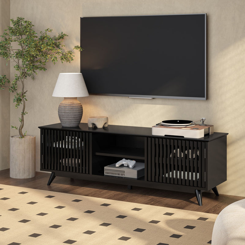 Modern living room with sleek black media console, flat-screen TV, indoor plant, and stylish table lamp.