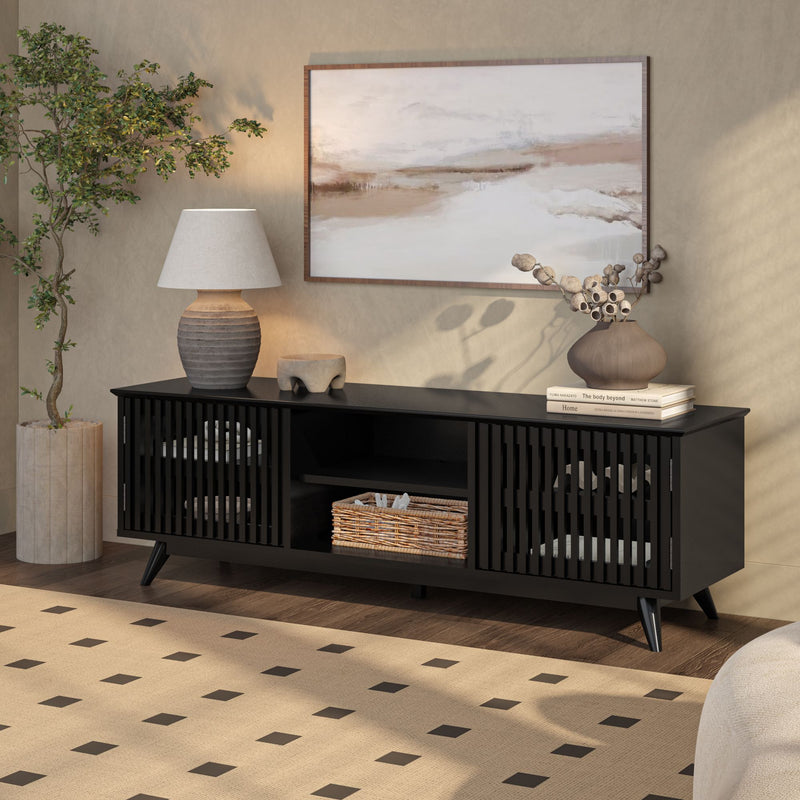 Modern living room with black media console, decorative lamp, indoor plant, and abstract wall art.