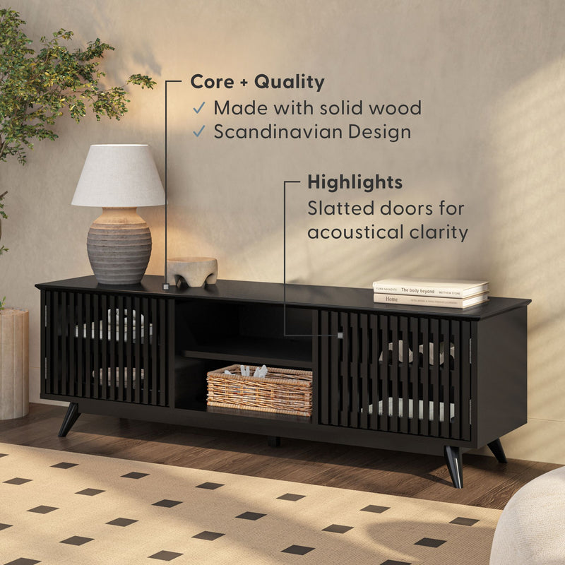 Modern Scandinavian TV stand in solid wood with slatted doors, enhancing acoustical clarity, complemented by a ceramic lamp and wicker basket arrangement.