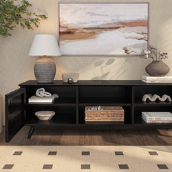 Modern living room interior with a stylish black console table, decorative objects, and a landscape painting above.