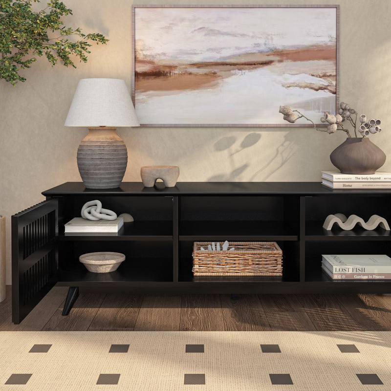 Modern living room interior with a stylish black console table, decorative objects, and a landscape painting above.