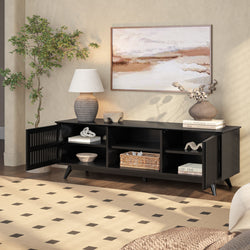 Modern black sideboard with decorative shelves, table lamp, abstract wall art, and indoor plant in cozy living room setting.