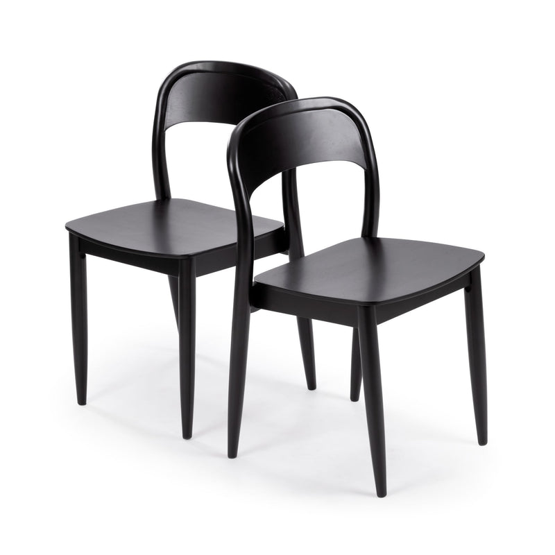 Two black wooden dining chairs with curved backrests and tapered legs on white background, minimalist modern kitchen seating